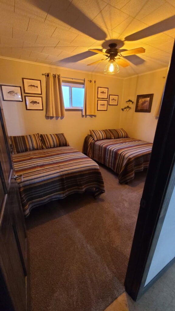 Fishing-themed guest bedroom with two beds at the Lazy A Ranch