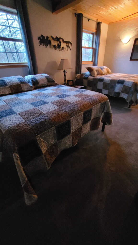 Guest bedroom with two beds and quilts at the Lazy A Ranch
