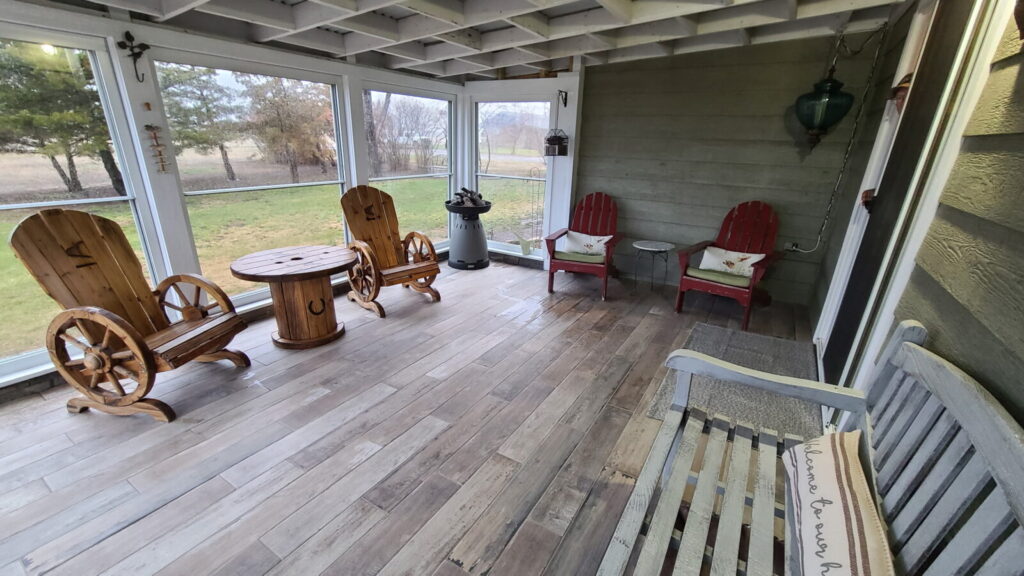 Enclosed porch with wagon-wheel chairs at the Lazy A Ranch